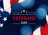 Veterans Day Concept - Veterans Day Message Sitting Over Dark Blue Background Next To Rippled American Flag