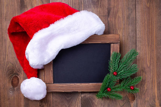 istock Empty chalk board or blackboard with Santa hat and Christmas tree branches, copy space horizontal 1350857390