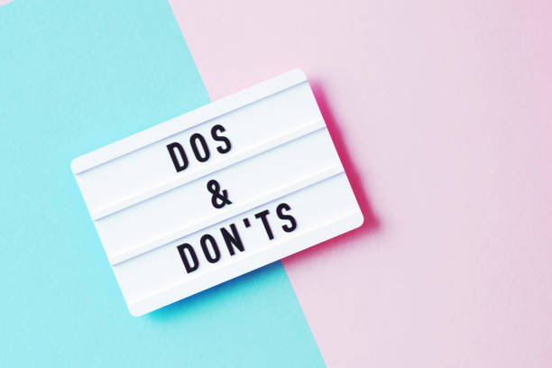 istock Dos And Don'ts Written White Lightbox Sitting On Pink And Blue Background 1350857747
