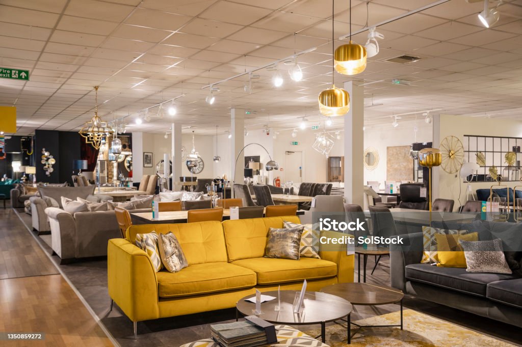 Luxury Furniture Goods A wide angle of a furniture store with no people in. There is various different sofas and lamps and furniture on the shop floor for display purposes. Furniture Store Stock Photo