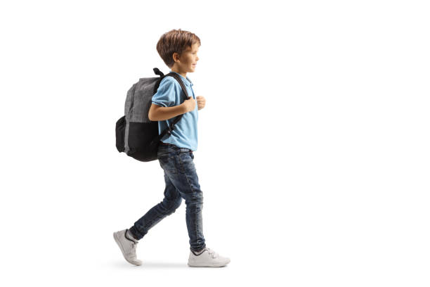 foto de perfil de cuerpo entero de un niño con una mochila caminando - child lifestyles isolated blue fotografías e imágenes de stock