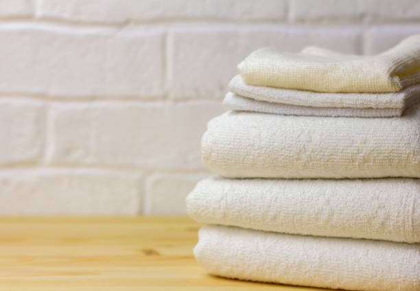 istock A stack of clean white towels lies on a wooden table. 1350860572