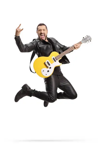 Male rock musician with an electric guitar jumping isolated on white background