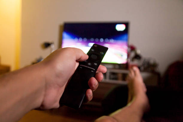 istock Man with smart TV remote control in hand 1350861238