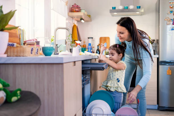 istock Mother and daughter washing dishes 1350867826