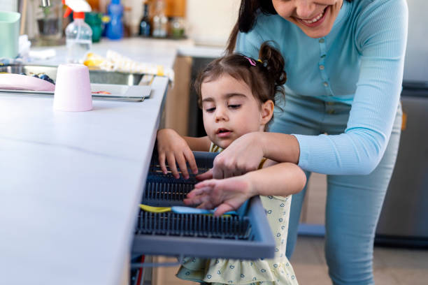 istock Mother and daughter washing dishes 1350867835