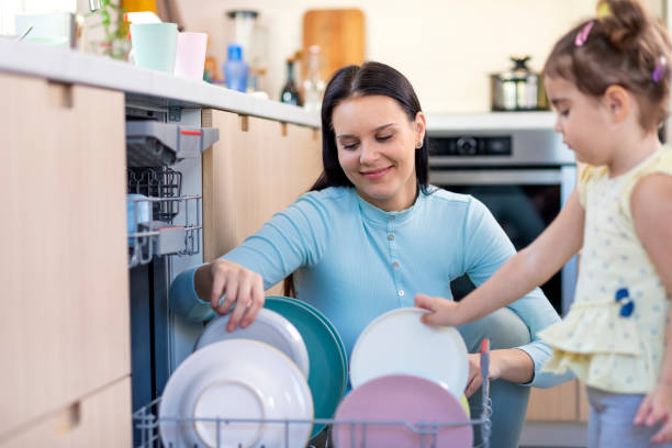 istock Mother and daughter washing dishes 1350867856