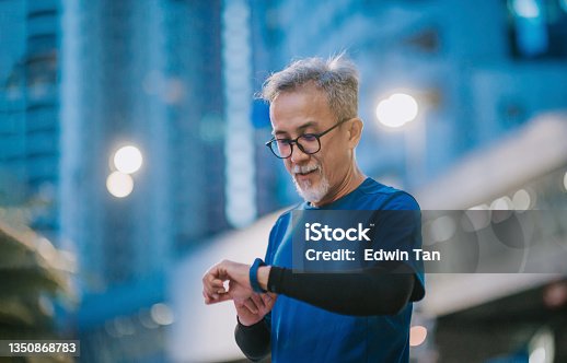 istock Asian chinese senior man checking his heartbeat with fitness tracker after running in the city during late evening 1350868783