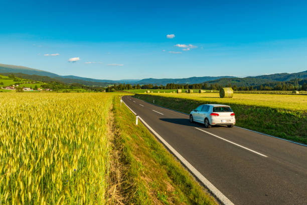 istock A white car drives between picturesque fields somewhere in Austria 1350874256