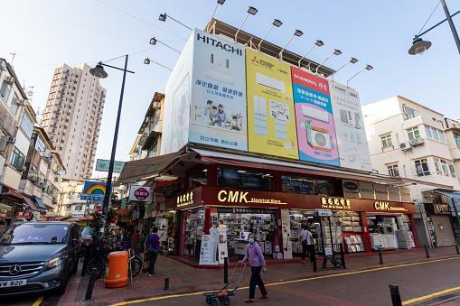 Hong Kong - November 2, 2021 : People walk past the CMK Electrical Store in Sheung Shui, New Territories, Hong Kong.