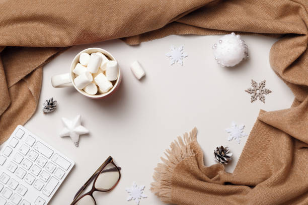 istock Winter desktop. New Year Christmas composition. Scarf keyboard glasses marshmallows on a white background. Flat lay top view 1350876583