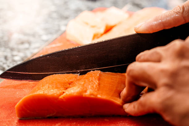 istock Chef using knife filleting salmon 1350878730