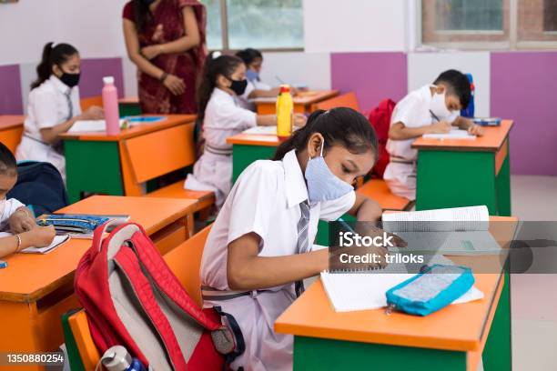 Students In Classroom Wearing Protective Face Mask After School Reopening Stock Photo - Download Image Now