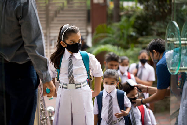Students getting temperature checked before entering school stock photo