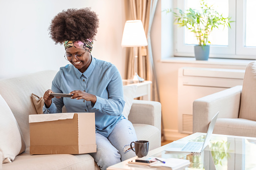 Young woman is taking a photo of the package she ordered online