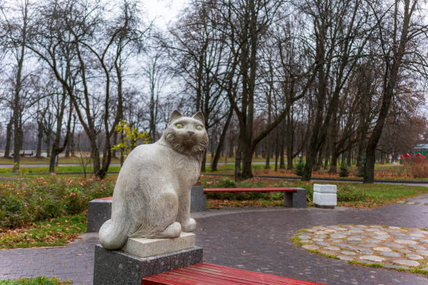 figure of a white cat made of granite in the park stock photo