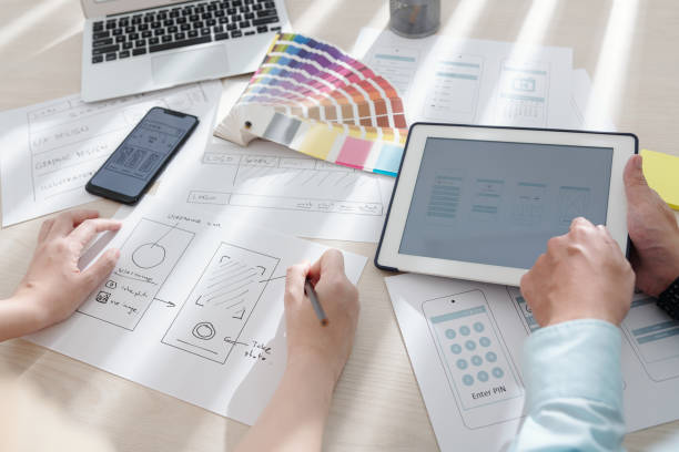 istock Designers Drawing Sketches of Mobile App 1350882218