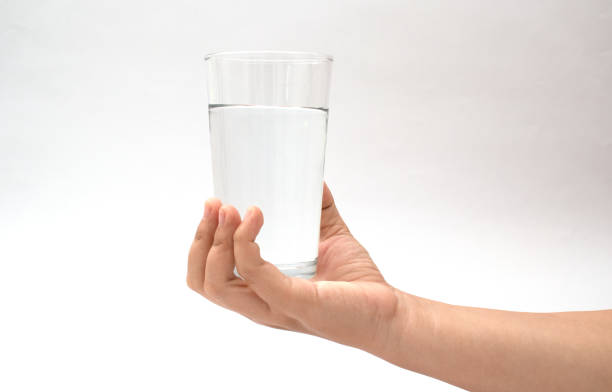 istock hand holding a glass cup on a white background 1350884056