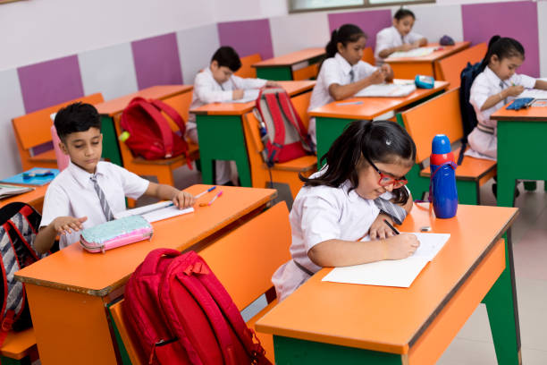 istock Group of students writing on book in classroom 1350887472