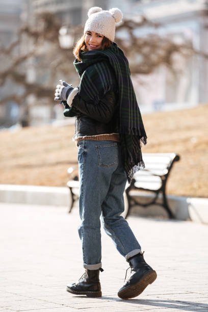 istock Happy woman walking and using cell phone outdoors in autumn 1350887644