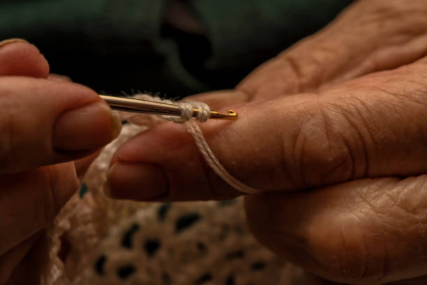 istock A 90-year-old lady crochets with white yarn at home 1350891365