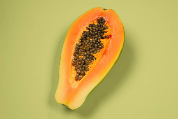 istock Papaya fruit on a green background. Half papaya. 1350894778