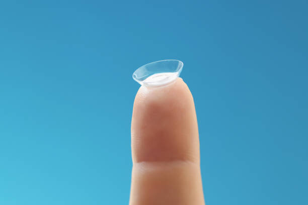 istock Soft contact lens on female finger on blue background 1350896108