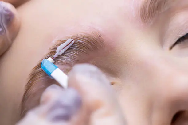 macro photography of the distribution of compositions with a special brush for laminating eyebrows