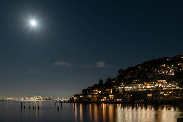 Sausalito hillside and moonlight A Sausalito hillside is silhouetted by the moon and residential lighting as reflected by the San Francisco Bay. sausalito stock pictures, royalty-free photos & images