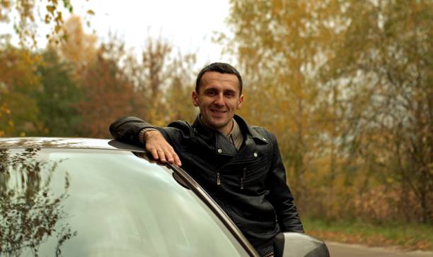 istock Cold autumn and a guy in a leather jacket near the car 1350899882