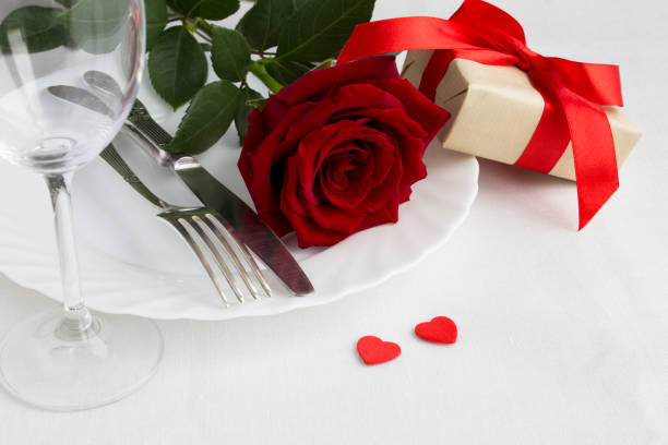 istock Valentine's day table setting with red rose and gift. Close-up. 1350901832