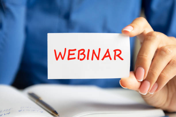 istock webinar written on a paper card in woman hand 1350903494