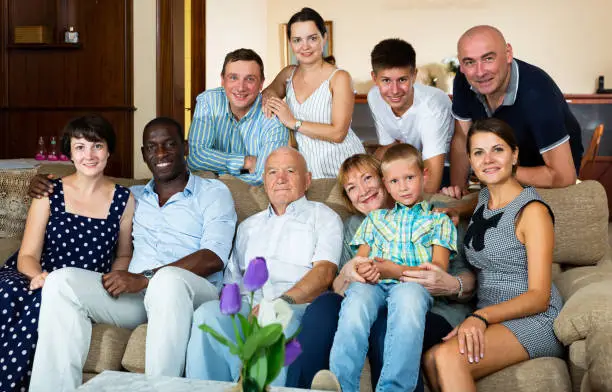 Portrait of big happy multigenerational family posing on sofa at home
