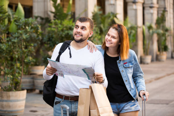 istock Couple of tourists with map and baggage hugging 1350904226