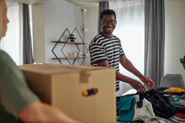 istock Diverse lovers helping each other for preparing their clothes for donations 1350904747