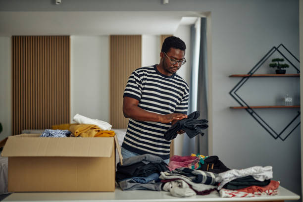 istock Black man folding clothes for donation 1350905597