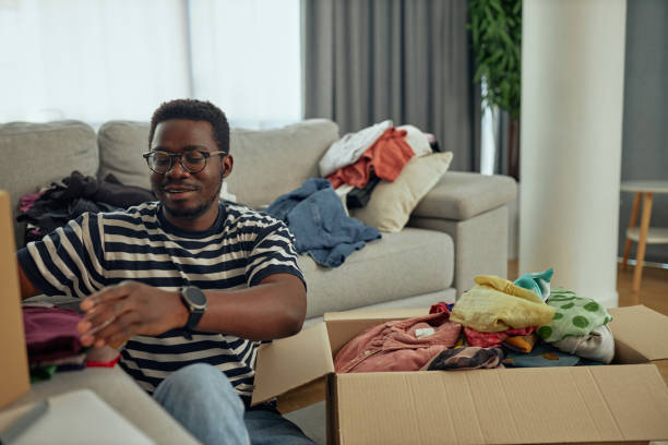 istock Black man with donation box with clothes 1350905645