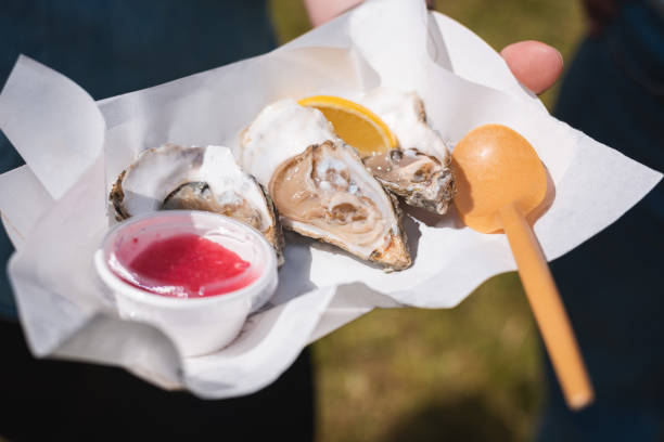 istock Delicious fresh oysters with lemon and sauce on a napkin 1350906565
