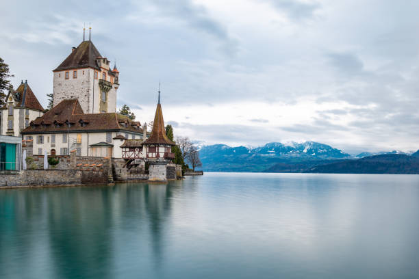湖の上の有名なスイスの城オベローフェン - berne europe tower fort ストックフォトと画像