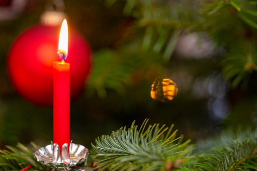 Advent wreath with red burning candles and Christmas decoration against a dark blue background with bokeh lights and stars, panoramic format, copy space, selected focus, narrow depth of field