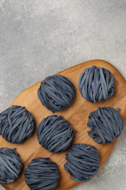 Photo of Raw organic wheat blue noodles with anchana flowers. The concept of a healthy and sporty lifestyle. butterfly pea flowers. Thai cuisine. Selective focus, Top view and Copy Space