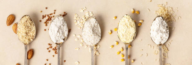 metal spoons of various gluten free flour almond flour, oatmeal flour, buckwheat flour, rice flour, corn flour , flat lay, top view - gluten allergy imagens e fotografias de stock