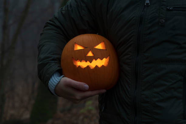 istock Man holds Halloween pumpkin head under the arm 1350912396