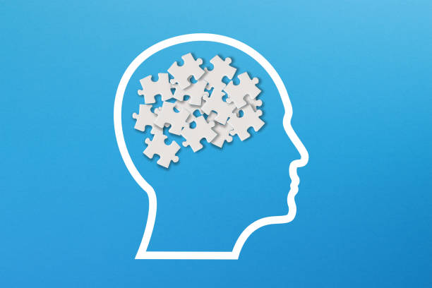 istock Confusion concept, mental health and problems with memory. Human brain shaped made of white jigsaw puzzles inside your head 1350913113
