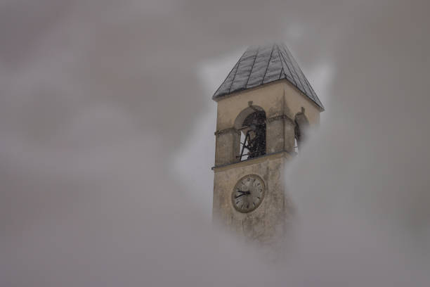 campanile di una chiesa del villaggio che si nasconde dietro un buco nella neve in ambiente invernale. chiesa di san rocco a vodo di cadore - san rocco foto e immagini stock