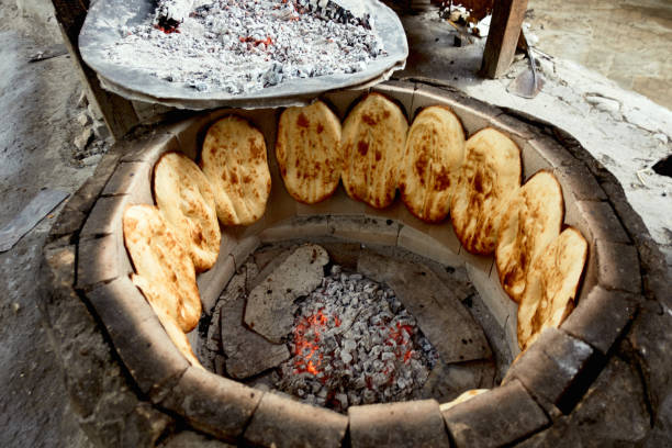 Traditional way of baking bread in the tandoor in Dagestan, Russia. Bread in the tandoor. Traditional way of baking bread in the tandoor in Dagestan, Russia. north caucasus photos stock pictures, royalty-free photos & images