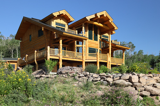 A modern luxurious multi story, log cabin built on the shore of a lake in the Idaho mountains.
