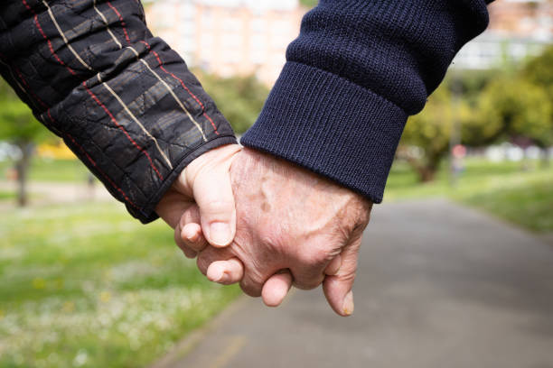 istock Senior couple holding hands in park 1350915529
