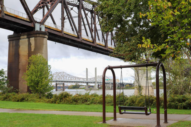 A empty park bench facing the Ohio River in Waterfront Park in downtown Louisville, Kentucky stock photo