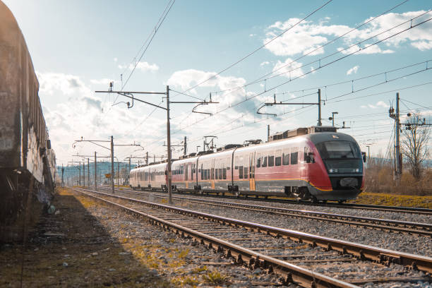 istock Red modern passenger train rushing through industrial district on a sunny afternoon 1350923298